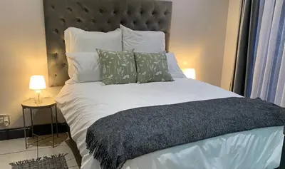 a bed with white sheets and pillows in a bedroom at Forest Hill in Pretoria