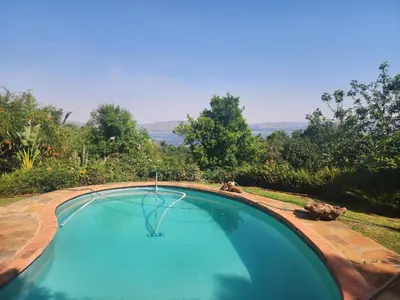 a swimming pool with a view of the ocean at Dam House Lodge in Hartbeespoort