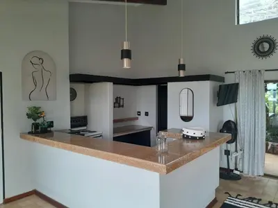 a kitchen with white walls and a counter top at Dam House Lodge in Hartbeespoort