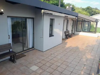 a patio of a house with glass doors at Dam House Lodge in Hartbeespoort