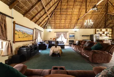 a large living room with couches and a table at Thatch Haven Guesthouse in Centurion