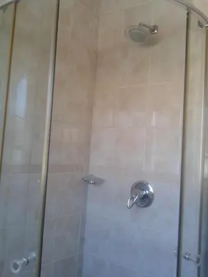 a shower with a glass door in a bathroom at Turquoise View Guesthouse in Middelburg