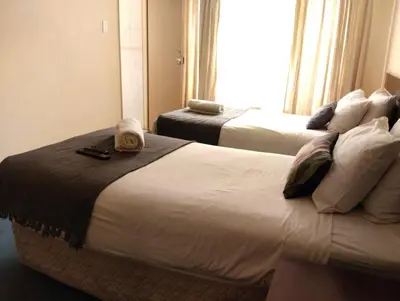 a hotel room with two beds with towels on them at Turquoise View Guesthouse in Middelburg