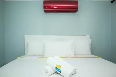 a white bed with two towels on top of it at HANA GUESTHOUSE in Pretoria