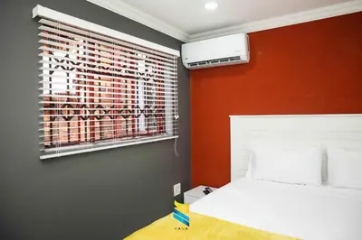 a bedroom with a white bed and a window at HANA GUESTHOUSE in Pretoria