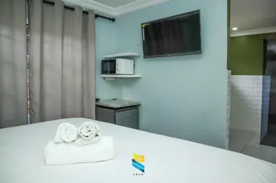 a room with a bed with towels and a microwave at HANA GUESTHOUSE in Pretoria