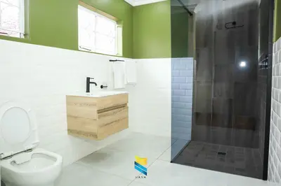 a bathroom with a shower and a toilet and a sink at HANA GUESTHOUSE in Pretoria