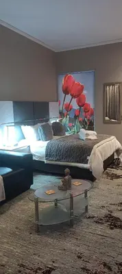a bedroom with a bed and a table in a room at Menlyn Maine Trilogy Apartment 1518 in Pretoria