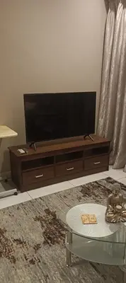 a living room with a flat screen tv and a table at Menlyn Maine Trilogy Apartment 1518 in Pretoria