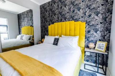 a bedroom with a large bed with a yellow headboard at Central Serenity @Midrand in Midrand