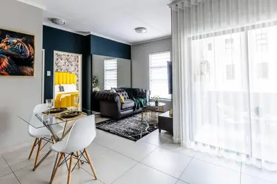 a living room with a table and chairs at Central Serenity @Midrand in Midrand
