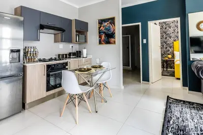 a kitchen with a table and chairs in a room at Central Serenity @Midrand in Midrand