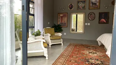 a living room with two chairs and a rug at The Lazy Leopard Lodge in Hoedspruit
