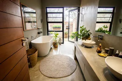 a bathroom with a tub and two sinks and a bath tub at The Lazy Leopard Lodge in Hoedspruit