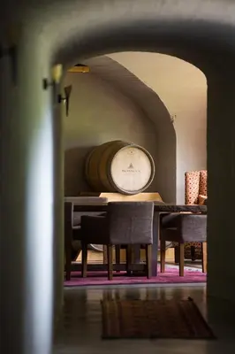a dining room with a table and chairs and a barrel at umVangati House in Hoedspruit