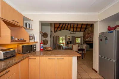 a kitchen with wooden cabinets and stainless steel appliances at Kruger Park Lodge Unit No. 246 in Hazyview