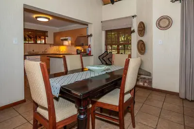 a kitchen and dining room with a table and chairs at Kruger Park Lodge Unit No. 246 in Hazyview