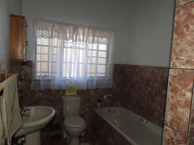 a bathroom with a toilet and a tub and a sink at Collin's Rest in Marloth Park