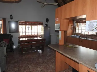 a kitchen with a counter and a table in a room at Collin's Rest in Marloth Park