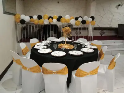 a table with white chairs and a black and yellow centerpiece at Ecotel Midrand in Midrand