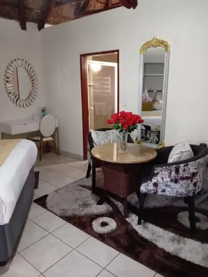 a bedroom with a bed and a table and a mirror at Ecotel Midrand in Midrand