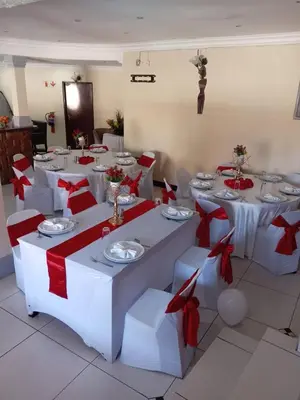 a room with white tables and chairs with red bows at Ecotel Midrand in Midrand