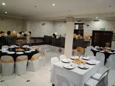 a banquet hall with white tables and chairs and balloons at Ecotel Midrand in Midrand