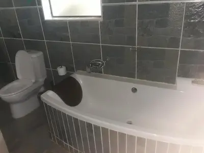 a bathroom with a bath tub and a toilet at Loding Lodge in Loding