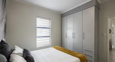 a bedroom with a bed and a large window at Beehive in Midrand