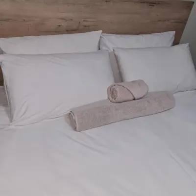 a white bed with two towels on top of it at Lukhanyo Guest House in Northam