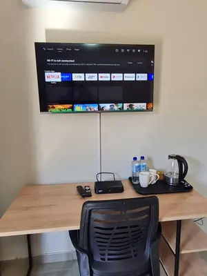 a desk with a computer monitor on a wall at Lukhanyo Guest House in Northam