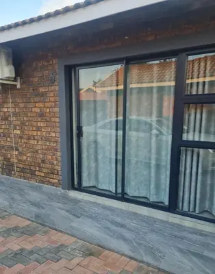 a sliding glass door on a brick house at Lukhanyo Guest House in Northam