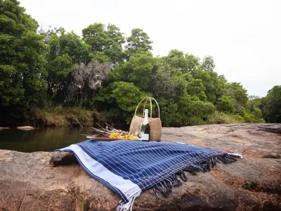 a blanket and a basket sitting on top of a rock at The Blyde Canyon House in Hoedspruit