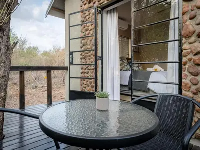 a patio with a table and chairs on a deck at The Blyde Canyon House in Hoedspruit