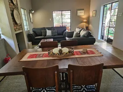 a living room with a table and a couch at The Blyde Canyon House in Hoedspruit