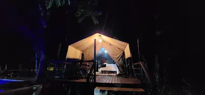 a tent with a table and chairs in it at night at Tot Hier Toe in Phalaborwa