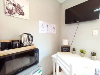 a kitchen with a microwave and a table with a coffee pot at OR Tambo Stay Unit 3 in Boksburg
