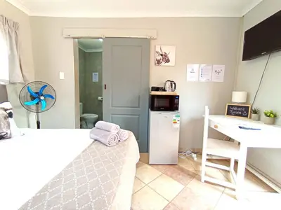 a small kitchen with a white refrigerator and a desk at OR Tambo Stay Unit 3 in Boksburg