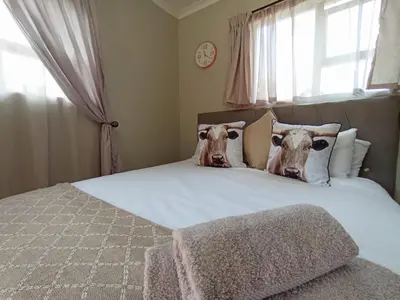 a bedroom with a bed with two cows on the pillows at OR Tambo Stay Unit 3 in Boksburg