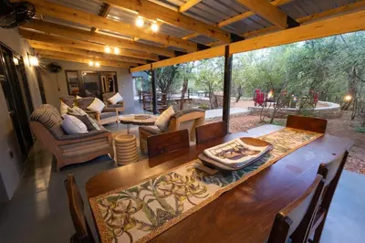 a dining room with a table and a large window at Africa House in Hoedspruit