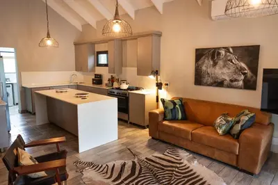 a kitchen and living room with a couch and a table at Africa House in Hoedspruit