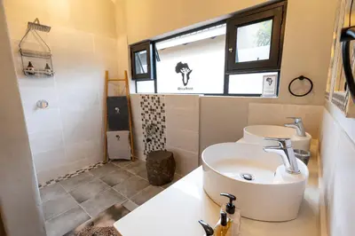 a bathroom with a toilet and a sink at Africa House in Hoedspruit