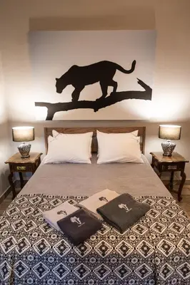 a bedroom with a tiger silhouette on the wall at Africa House in Hoedspruit