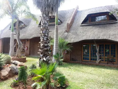 a house with two palm trees in front of it at Siesta Guest House in Musina