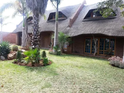 a house with palm trees in the yard at Siesta Guest House in Musina