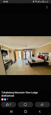 a view of a bedroom with a bed and a desk at TSHABELANG MOUNTAIN VIEW LODGE in Burgersfort