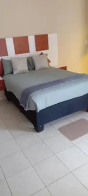 a large bed in a room with a white floor at TSHABELANG MOUNTAIN VIEW LODGE in Burgersfort