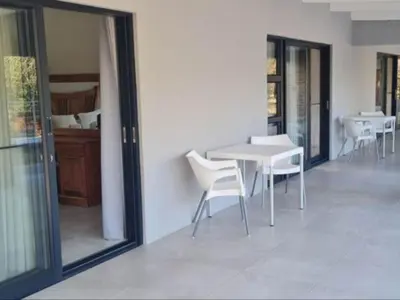 a dining room with a white table and chairs at Tswenyane Kruger Lodge in Marloth Park