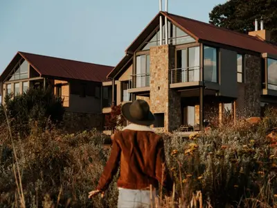 a woman walking in front of a house at Sensiri Myst Country House in Dullstroom