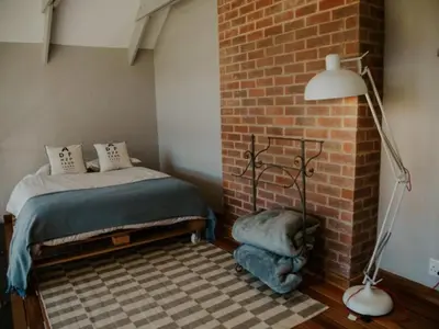 a bedroom with a bed next to a brick wall at Sensiri Myst Country House in Dullstroom